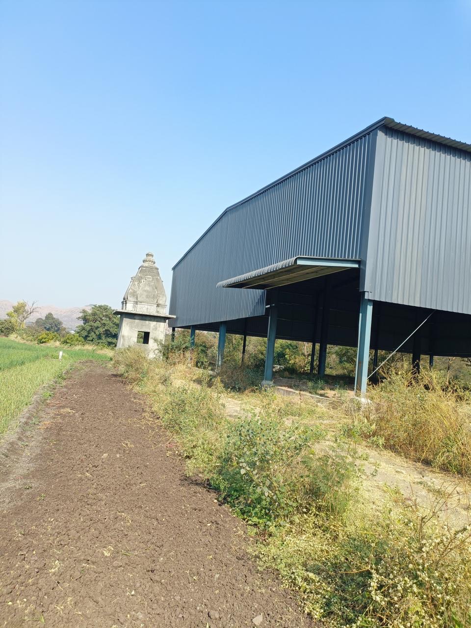 Industrial land site with a completed steel structure in a rural Pune setting