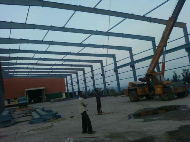 Steel structure erection site with crane, approved and under active construction