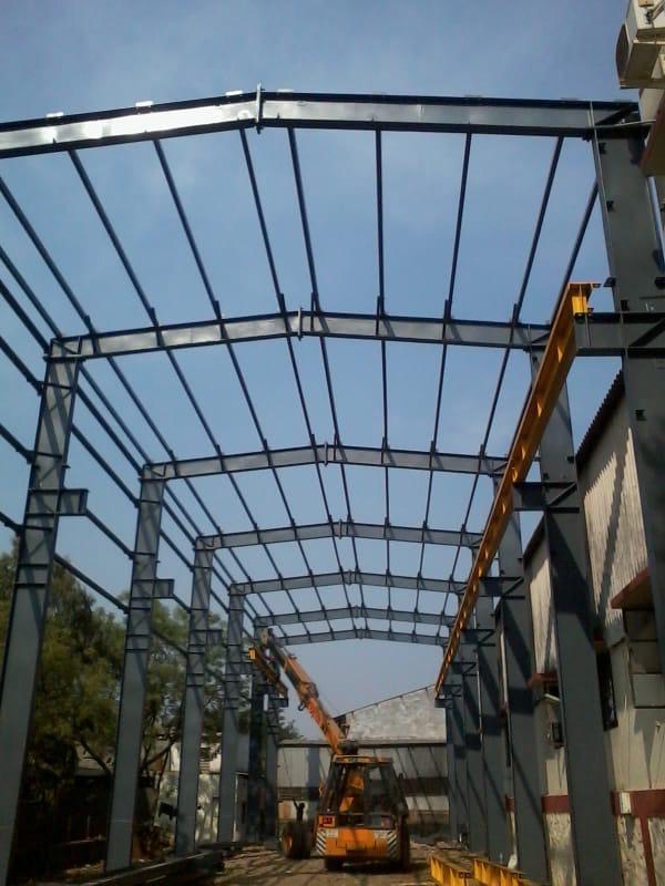 Crane placing a fabricated steel frame member during erection