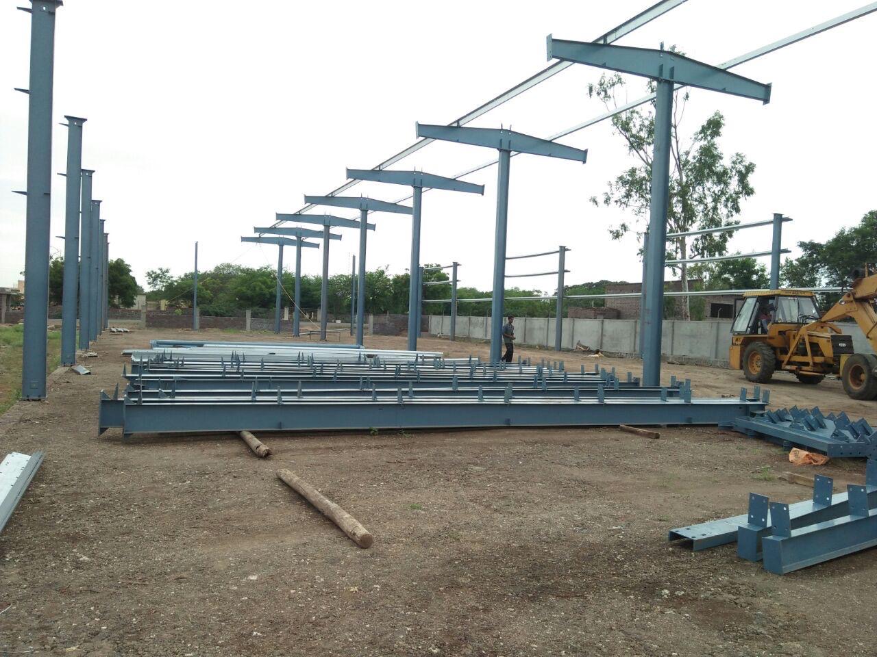 Ground-level assembly of steel trusses and purlins before crane erection